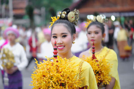LAMPHUN, THAILAND - MAY 12, 2019 : The girl holds the flower pan in the festival festival. Bathing Phra That Chedi Hariphunchai in Lamphun, Thailand.のeditorial素材