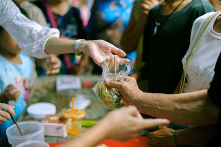 The concept of food is essential to life : the concept of hope : Hand-feeding to the needy in society : Concept of Feeding : Volunteers give food to the poorのeditorial素材