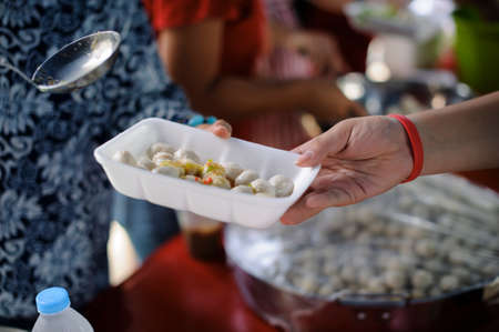 Food needs of the poor in society Help with Food Donation : Homeless people pick up charity food...