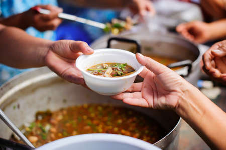 Homeless people are helped with food relief, famine relief : volunteers giving food to poor people...