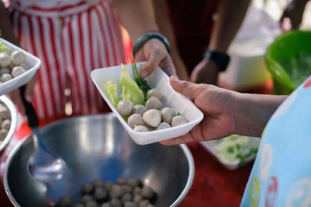The concept of humanitarianism : The hands of refugees have been aided by charity food to alleviate hunger : Feeding Concepts : Hand offered to donate food from a rich man Shareの写真素材