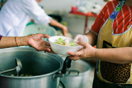 The concept of humanitarianism : The hands of refugees have been aided by charity food to alleviate...