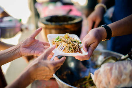 Poor people receiving food from donations : Homeless people are helped with food relief, famine...