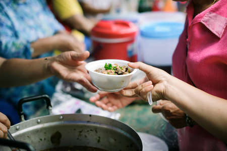 The concept of social sharing : Poor people receiving food from donations : Homeless people are...