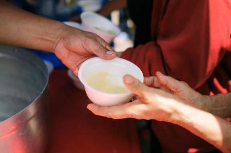 The Hand of the Beggars receives charity food from fellow human beings : The concept of humanitarianism : The hands of refugees have been aided by charity food to alleviate hunger : Feeding Conceptsの写真素材