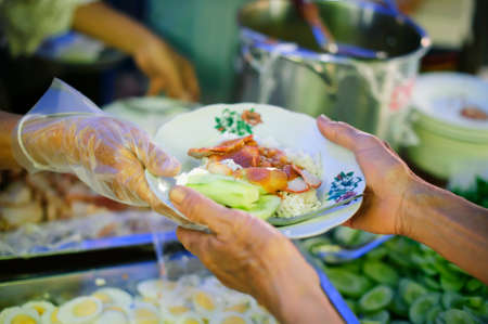 The Hope of the Poor by Donating Charity Food to the Immaculate : Participation in sharing food for the poor : The Concept of Love : The beggar is waiting for food from charity aidの写真素材