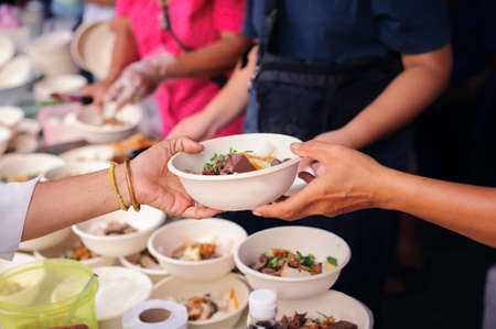 Concept of famine and social inequality : Free food for the poor and Food distribution : Sharing Food With Homeless : concept Tackling Hunger and Foodの写真素材