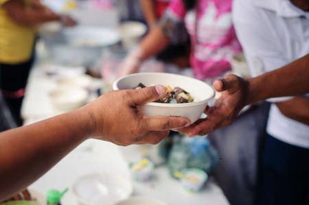 The poor people bring a container to scoop food to eat and relieve hunger and bring home : The...