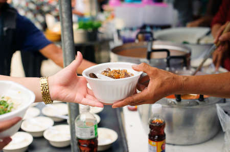 Concept of famine and social inequality : feeding food for beggar poverty concept : The society of helping to share food to the poor : Serving the Homeless Hungry and Poorの写真素材