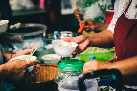 Volunteers serving food for poor people : concept of free food servingの写真素材
