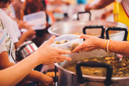 Volunteers give away free food to hungry people : concept of care And feedingの写真素材