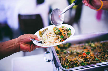 Volunteers donate food to those who need food to alleviate hunger, the poor receive charity food...