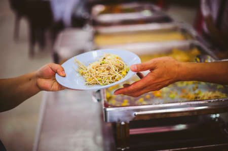Volunteers give away free food to hungry people : concept of care And feedingの写真素材