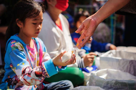 Chiang Mai, Thailand - OCTOBER 20, 2019 : Children and the poor are waiting to receive donations and money from philanthropists in Chiang Maiのeditorial素材