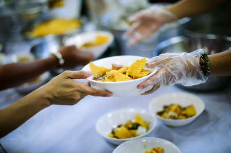 Homeless people receive food from volunteers: the concept of feeding