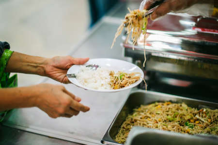 Volunteers provide free food to the poor with care : concept of begging for foodの写真素材