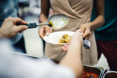 The society of sharing: the hands of donors requesting food from generous people: concept of givingの写真素材