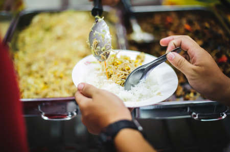 Food Sharing Society: Volunteers are sharing food to hungry people in society.の写真素材