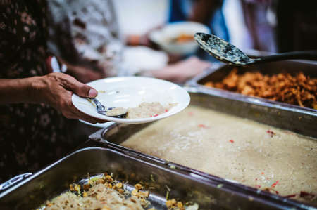 Volunteers provide free food to the poor with care : concept of begging for foodの写真素材