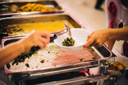 Warm food scooped from ladle into a container of the poor: the concept of givingの写真素材