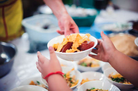 Homeless people receive free food from compassionate people: the concept of food needsの写真素材