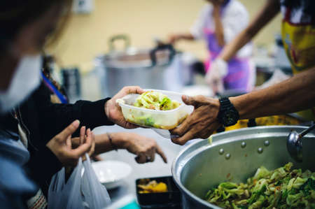 Providing free charity food to needy people: the idea of donating foodの写真素材