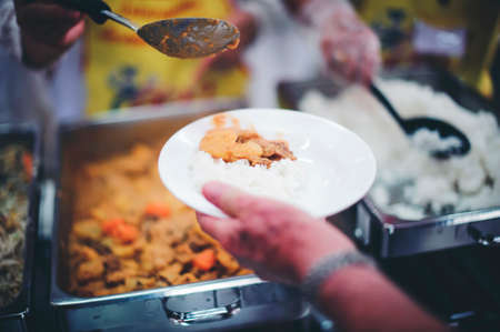 The hands of the poor are waiting to receive food from the rich, compassionate, free food donations...