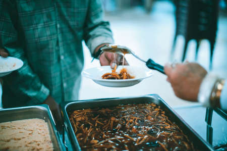 Homeless and needy people receive help, receive food from volunteers : concept of food donation
