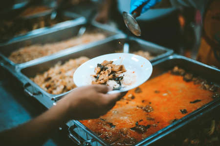Poor people receive donated food from donors: The hands of the poor receive food from the hands of...