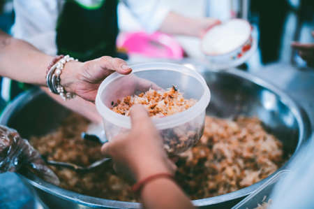 The hands of the poor have been begging to donate food from the donor, The concept of feedingの写真素材