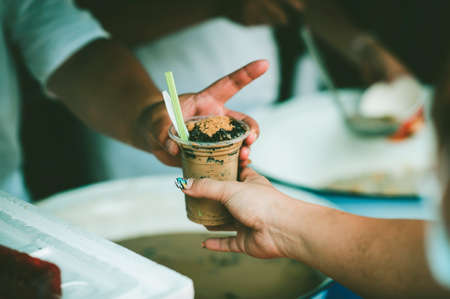 Feeding to the poor to hands of a beggar : concept of feeding food for beggarの写真素材