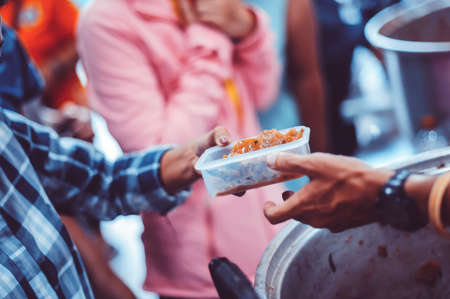 The donor gives food to the poor in Asian society : concept of sharing food to the poorの写真素材