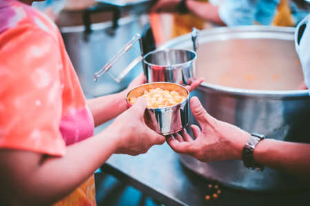 Hands of beggars accepting food from the hands of volunteers