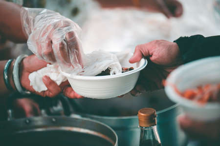Homeless people wait to receive food donations from donors : The concept of povertyの写真素材