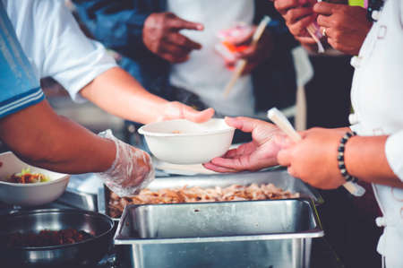 Hands of volunteers serves free food to the poorの写真素材