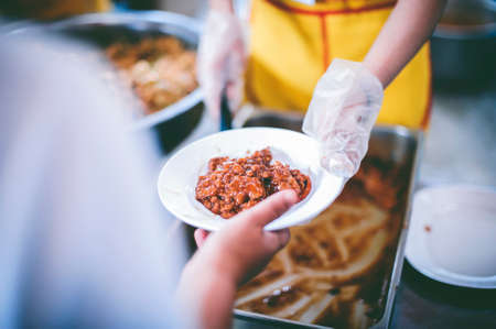 Hands of volunteers serves free food to the poorの写真素材