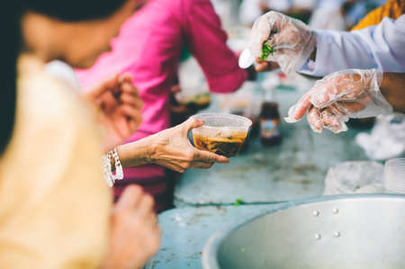 The hands of the poor get free food from the volunteers : the concept of ââsharing foodの写真素材