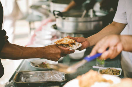 The concept of starvation : The hands of beggars receive donated foodの写真素材