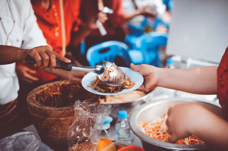 The hand of a beggar receives food from the donor: Donate food to hungry peopleの写真素材