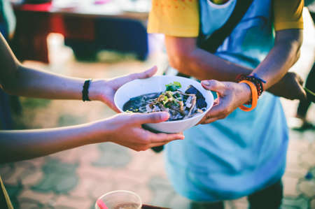 Volunteers give food to the poor: concept of charity food for the poorの写真素材