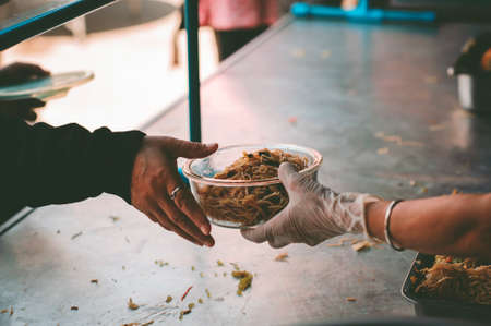 The hands of poor have been aided by charity food to alleviate hunger: The concept of social sharingの写真素材