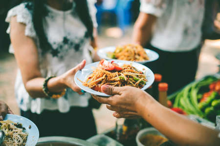 The hands of poor have been aided by charity food to alleviate hunger: The concept of social sharingの写真素材