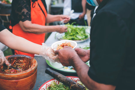 Volunteers donating food to people in a society in need of food: the concept of helping with food.の写真素材