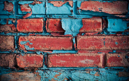 Red brick wall, disintegrated, weathered surface.