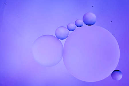 translucent oily liquid bubbles on the water surface, oil drops on the water surface