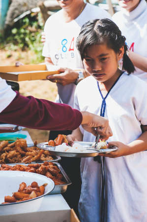 MAE HAE NOI OMKOI CHIANG MAI, THAILAND - JANUARY 10 , 2019 : Volunteers donate lunch to the children in Chiang Mai, Thailandのeditorial素材