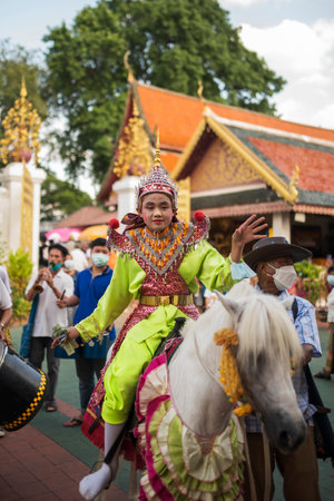 LAMPHUN, THAILAND - MAY 15, 2022: Thai teenage boys dressed in traditional costumes wearing crowns...
