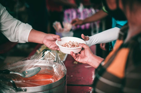 Volunteers come to donate food to hungry people : the concept of sharingの写真素材