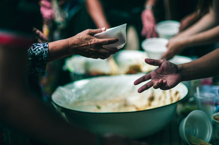 Hands of hungry beggar requesting free food from volunteers : concept of giving and sharing
