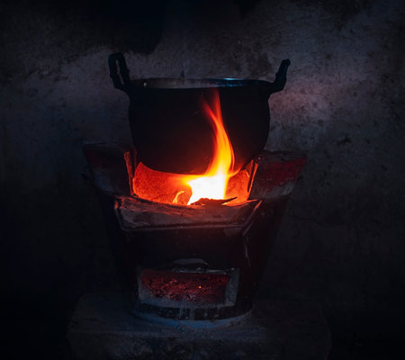 The cooking pot sits on a blazing coal stove.